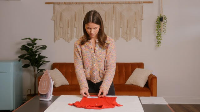 Cait demonstrates how to iron on a Safely Back Home ID decal.